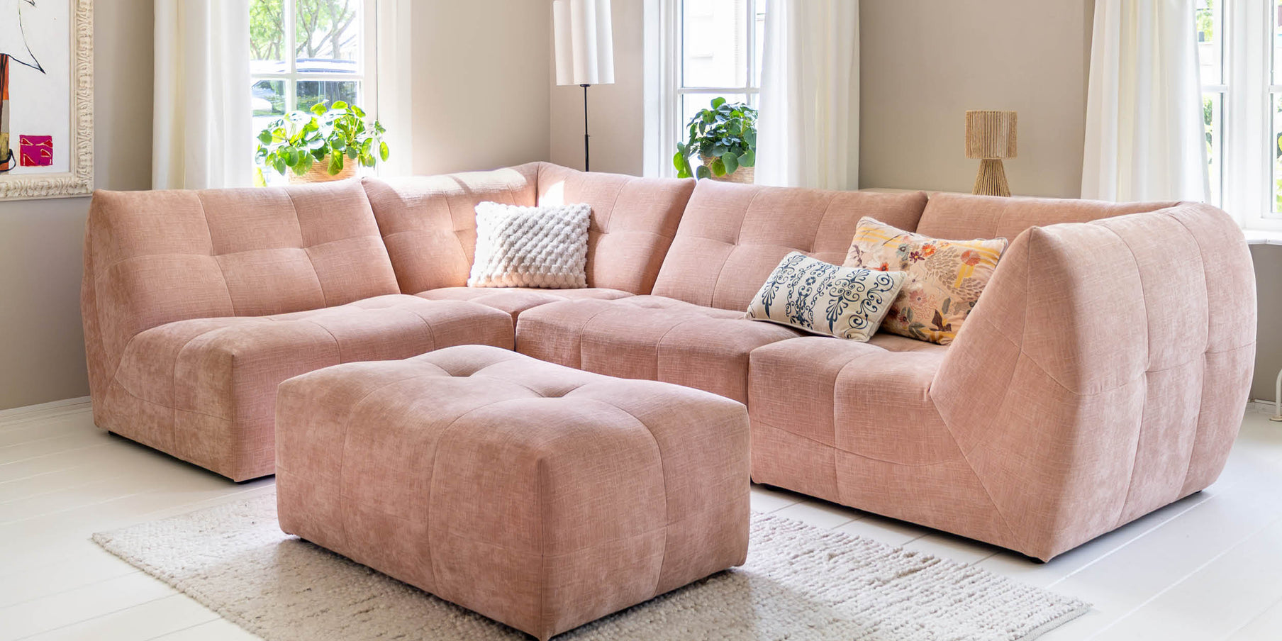 Roze designbank als kleuraccent in een lichte woonkamer